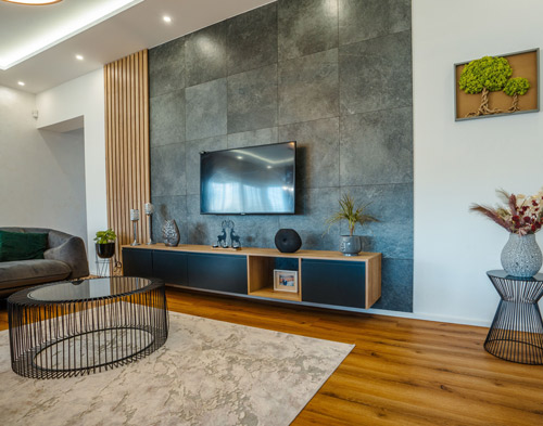 Modern living room with a sleek entertainment unit, decorative plants, and stylish furniture.