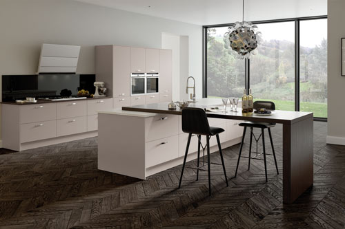 A fitted kitchen in surrey with a breakfast bar and big windows