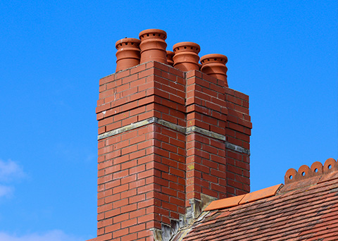 brick chimney with four pots against clear blue sky representing quality construction and aesthetic appeal 11 modern designs 11 architectural features