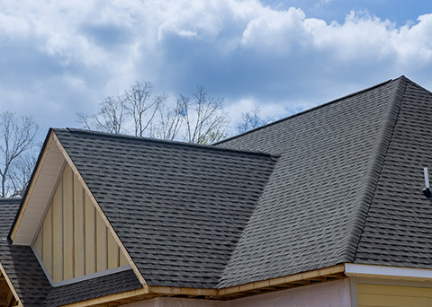 new roof installation with textured shingles under a blue sky showcasing craftsmanship and quality materials for four season durability