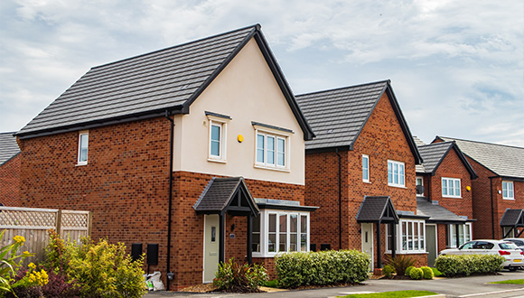 two brick houses with tiled roofs and neatly landscaped front gardens in a residential neighborhood showcasing modern architecture and community living 3 homes 3 style 3 design