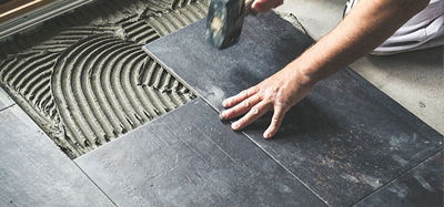 A person installing kitchen tiles