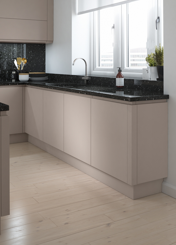 A modern kitchen with simple cabinets and black worktops