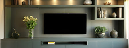A media wall with sage green cabinates